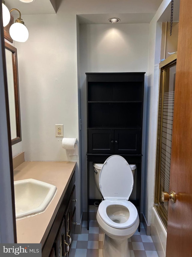 full bathroom featuring vanity, enclosed tub / shower combo, and toilet