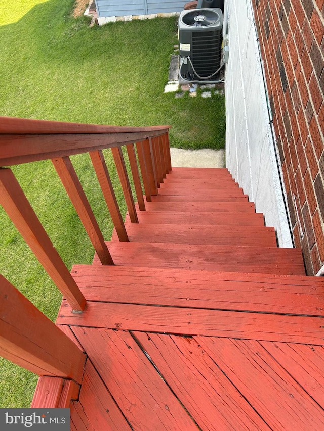 wooden deck featuring central AC and a yard