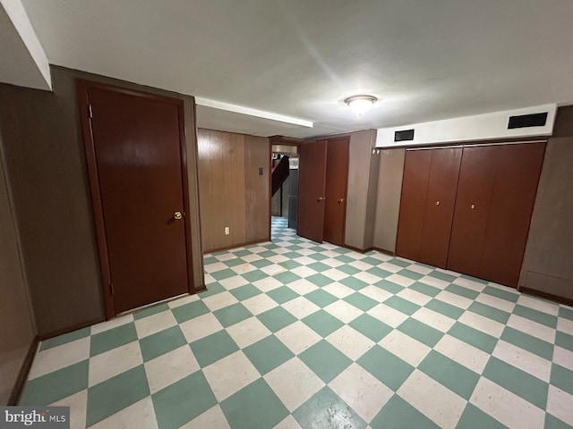 basement featuring wood walls