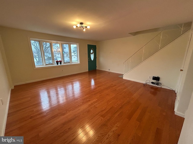 unfurnished living room with hardwood / wood-style floors and an inviting chandelier