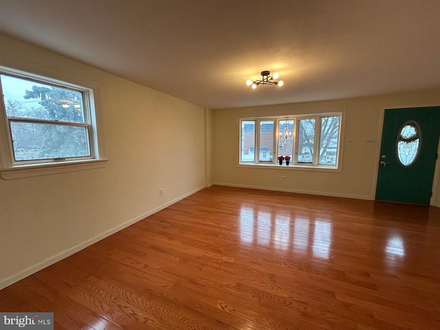 interior space featuring plenty of natural light, wood-type flooring, and a chandelier