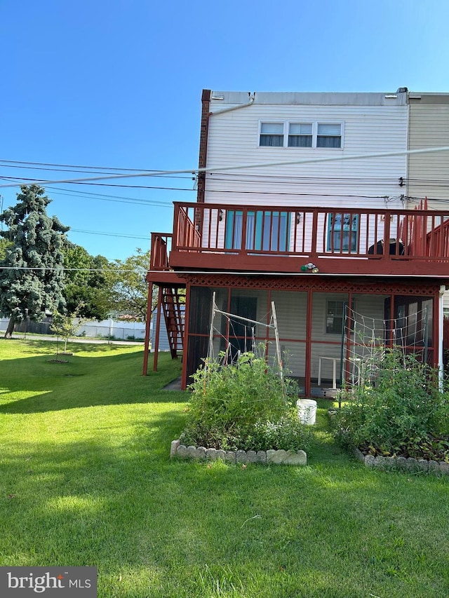 back of house with a lawn and a deck