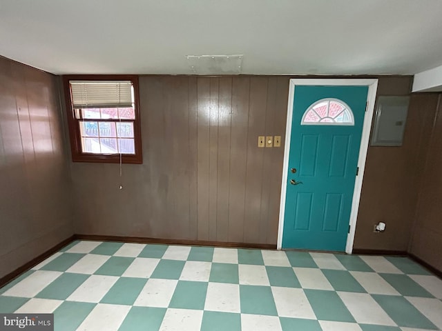 entrance foyer featuring wood walls and electric panel