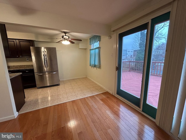 kitchen with ceiling fan, light hardwood / wood-style floors, dark brown cabinetry, and stainless steel refrigerator