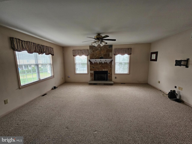 unfurnished living room with ceiling fan, carpet floors, and a fireplace