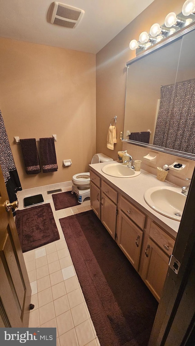 bathroom featuring vanity, toilet, and tile patterned flooring