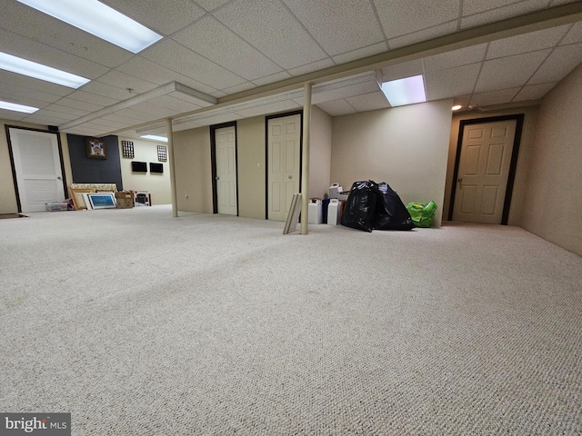 basement featuring a drop ceiling and carpet