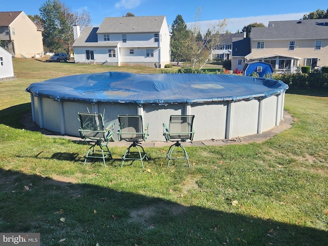 view of pool featuring a lawn