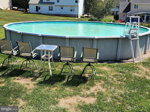 view of pool with a lawn