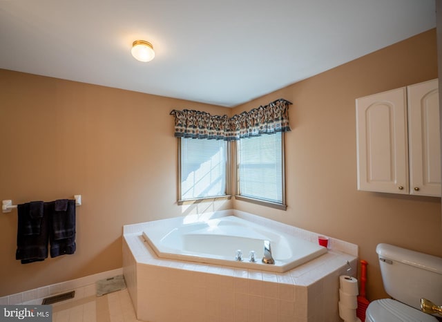 bathroom with a relaxing tiled tub and toilet