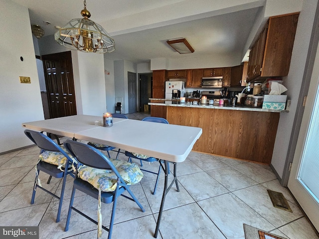 dining space with light tile patterned floors and a chandelier