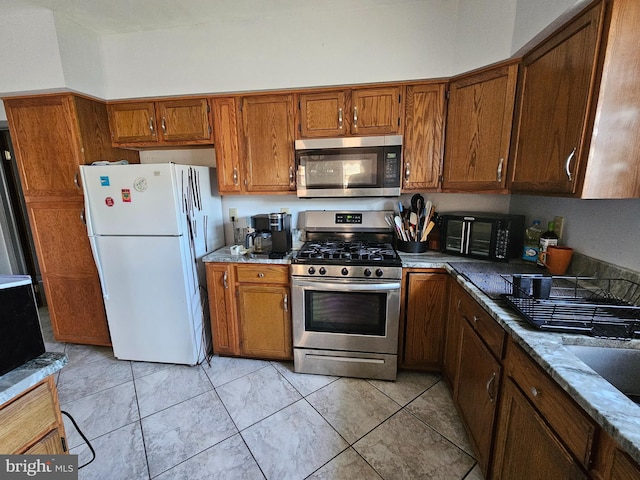 kitchen with appliances with stainless steel finishes and light stone countertops