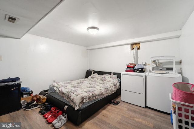 bedroom with wood-type flooring and washer and clothes dryer