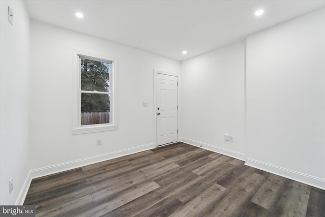 unfurnished room with dark wood-type flooring