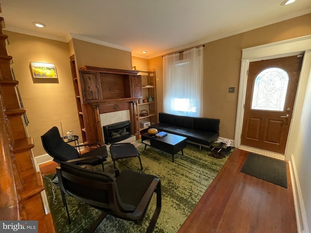 living room featuring hardwood / wood-style floors, ornamental molding, and a fireplace