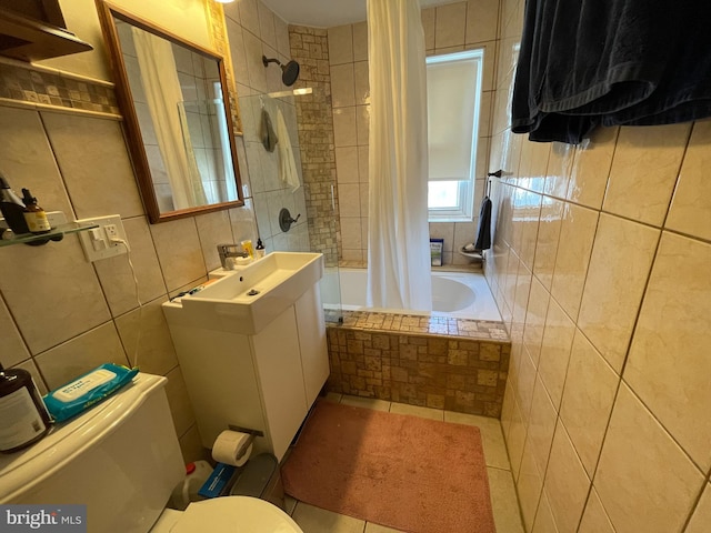 full bathroom with sink, tile patterned flooring, toilet, shower / bath combo with shower curtain, and tile walls