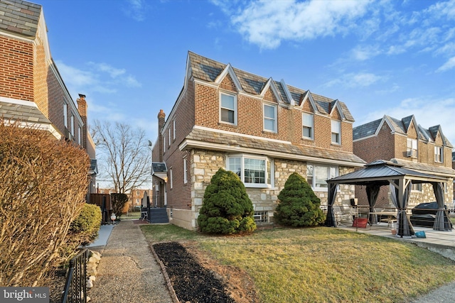 view of front of property featuring a front yard and a gazebo