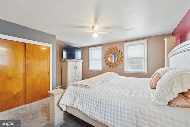 carpeted bedroom with ceiling fan and a closet