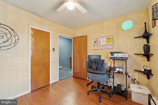 home office with hardwood / wood-style floors and ceiling fan