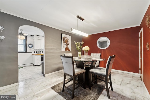 dining space with a baseboard heating unit, ceiling fan, and ornamental molding