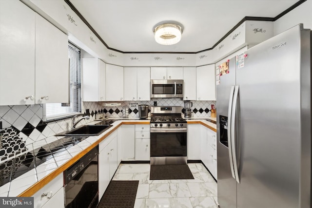 kitchen featuring white cabinets, tile counters, sink, and appliances with stainless steel finishes