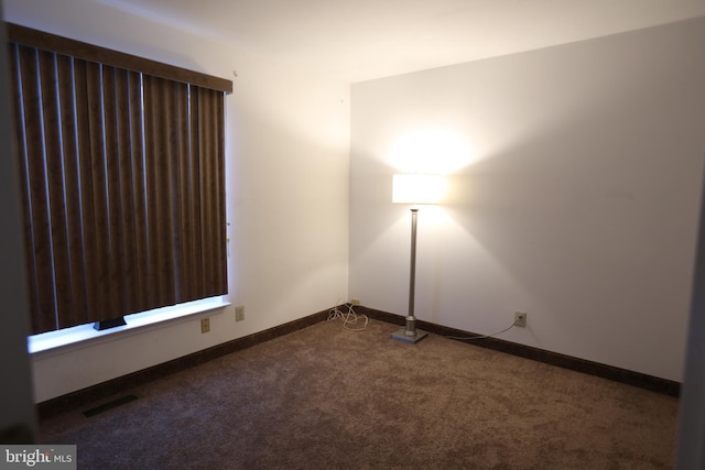 empty room with dark colored carpet