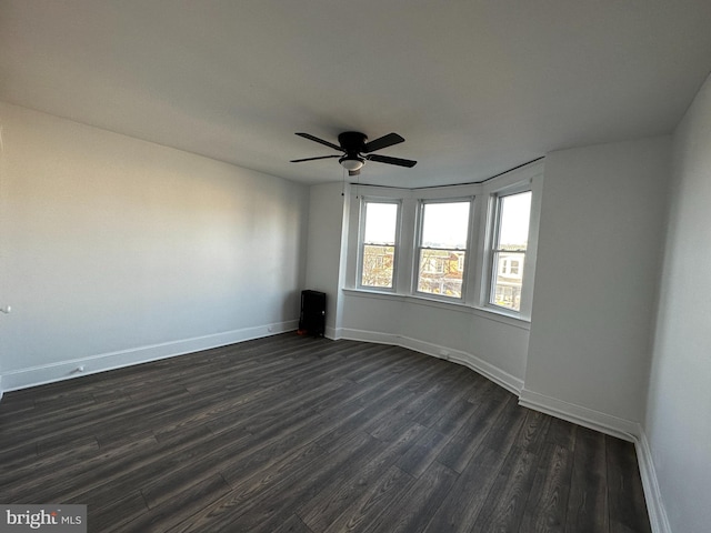 spare room featuring ceiling fan and dark wood-type flooring