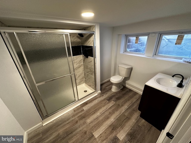 bathroom featuring hardwood / wood-style floors, toilet, an enclosed shower, and vanity