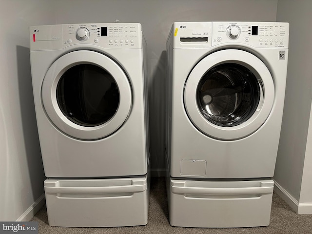 clothes washing area featuring washer and clothes dryer