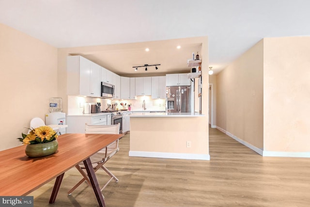 kitchen with white cabinetry, sink, appliances with stainless steel finishes, and light hardwood / wood-style flooring