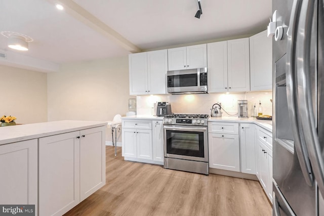 kitchen featuring backsplash, white cabinetry, stainless steel appliances, and light wood-type flooring