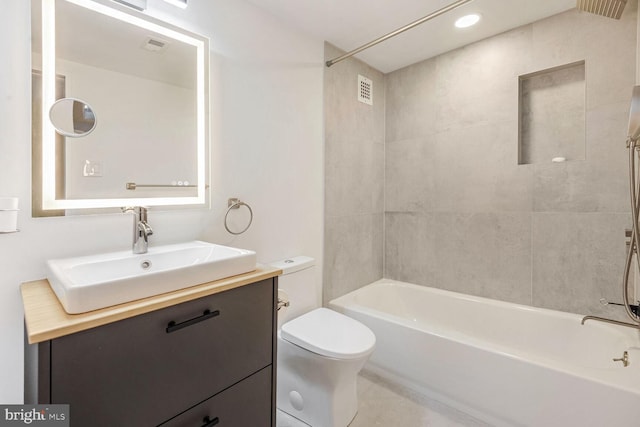 full bathroom featuring vanity, toilet, and tiled shower / bath combo