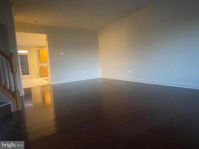 spare room with dark wood-type flooring