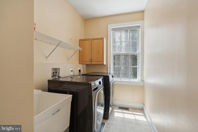 laundry area with sink, cabinets, and independent washer and dryer