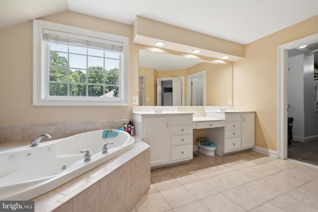 bathroom featuring tile patterned flooring, vanity, vaulted ceiling, and tiled tub