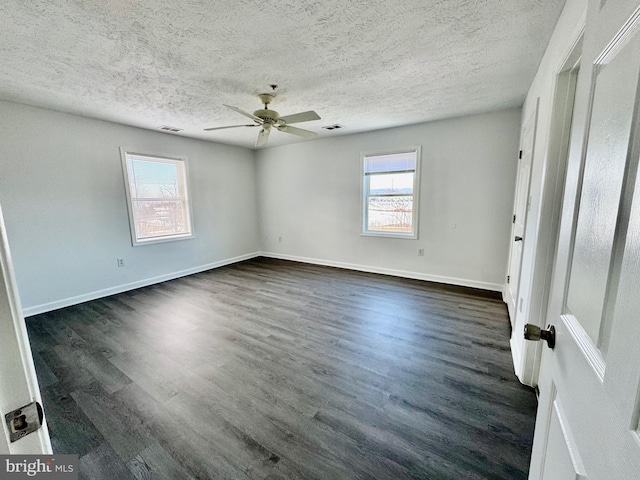 spare room featuring dark wood-type flooring, ceiling fan, and a textured ceiling