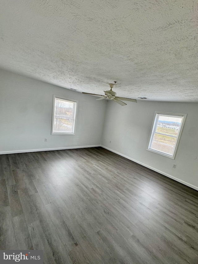 spare room with a textured ceiling, dark hardwood / wood-style flooring, and ceiling fan