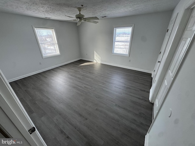 spare room with ceiling fan, dark hardwood / wood-style floors, and a textured ceiling