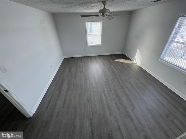 spare room with a textured ceiling, dark wood-type flooring, and ceiling fan