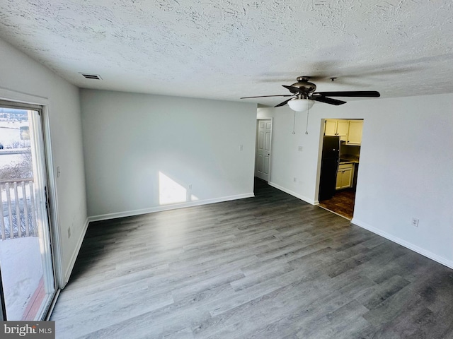 empty room featuring dark hardwood / wood-style flooring, a textured ceiling, and ceiling fan