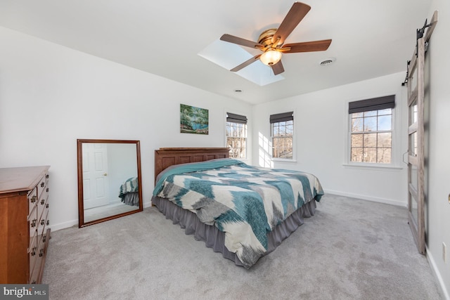 carpeted bedroom featuring ceiling fan and a skylight