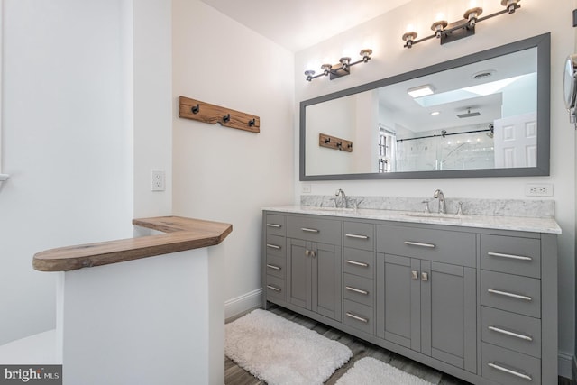 bathroom with vanity and a shower with door