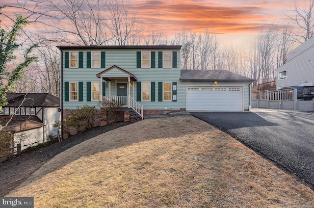 view of front of house with a yard and a garage