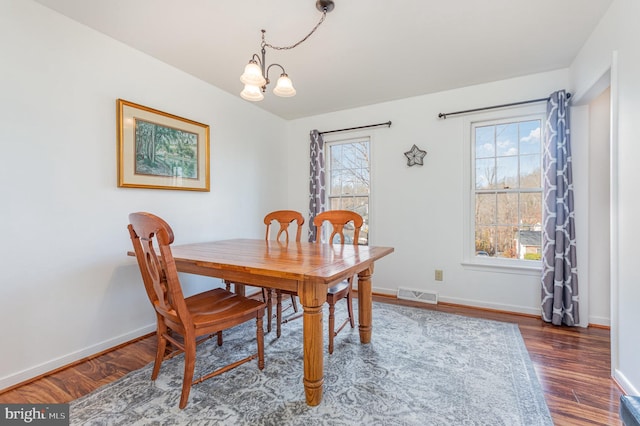 dining room with an inviting chandelier and dark hardwood / wood-style floors