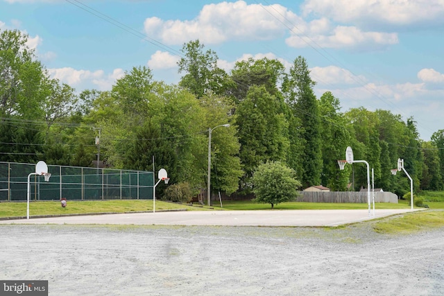 view of sport court featuring a lawn