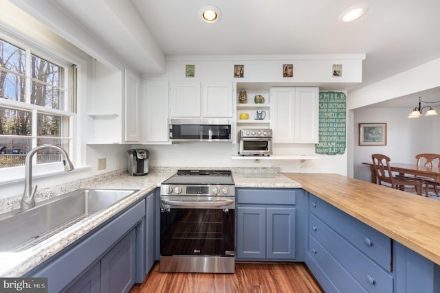 kitchen featuring blue cabinets, sink, wood-type flooring, appliances with stainless steel finishes, and white cabinets