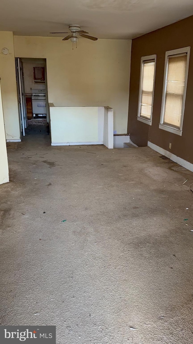 unfurnished living room featuring ceiling fan and carpet