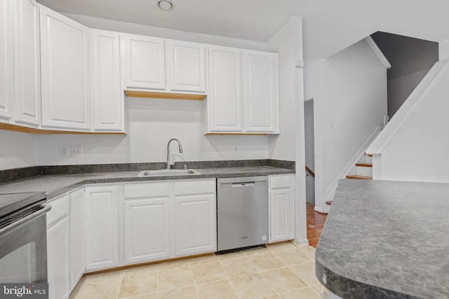 kitchen with white cabinetry, appliances with stainless steel finishes, sink, and light tile patterned floors