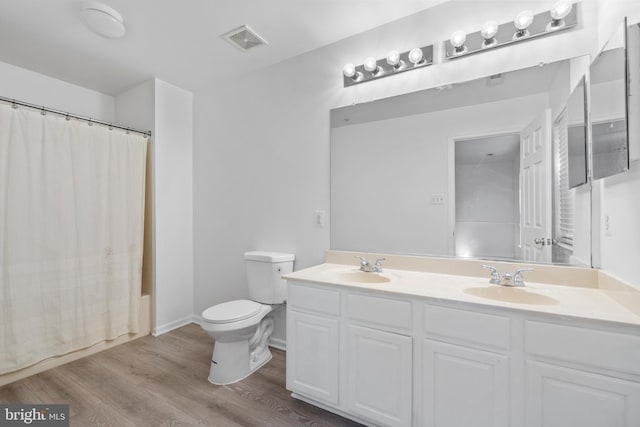 full bathroom featuring vanity, wood-type flooring, toilet, and shower / bathtub combination with curtain