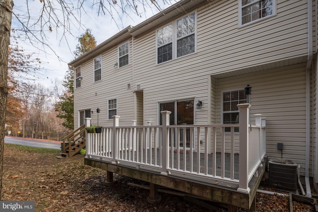 rear view of property featuring cooling unit and a deck